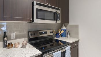 A kitchen with a stove and a microwave in it